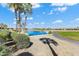 Scenic view of a pond and lush green landscaping with palm trees and walking path near the property at 20609 N Canyon Whisper Dr, Surprise, AZ 85387