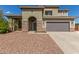 Charming two-story home with a two-car garage, desert landscaping, and a covered porch with stone accents at 2136 W Pickett Ct, San Tan Valley, AZ 85144