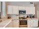 Bright kitchen featuring white cabinets, marble countertops, and stainless steel appliances at 2448 S Salida Del Sol --, Chandler, AZ 85286