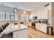 Well-lit kitchen with white cabinetry, marble countertops, stainless steel appliances, and wood-look flooring at 2448 S Salida Del Sol --, Chandler, AZ 85286