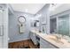 Bright bathroom features dual sinks, wood floors, and octagon-shaped mirror at 2673 Leisure World --, Mesa, AZ 85206