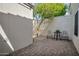 Paver patio with table and chairs surrounded by neutral stucco wall with tree at 2814 N 62Nd N St, Scottsdale, AZ 85257