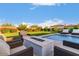 Lush backyard features a pool, fire pit, manicured lawn and cozy seating area at 30271 N 117Th Dr, Peoria, AZ 85383
