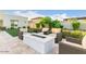 Backyard with a travertine patio, fire pit, chairs and lush landscaping at 30271 N 117Th Dr, Peoria, AZ 85383