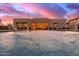 An amazing backyard featuring a beautiful pool, fountains, and string lights reflecting on the water under a colorful sky at 30271 N 117Th Dr, Peoria, AZ 85383