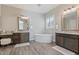 A large bathroom features two vanities and a stand-alone tub with natural light from the window at 30271 N 117Th Dr, Peoria, AZ 85383