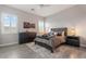 Comfortable bedroom features a gray platform bed, dark wood furniture, and natural light at 30271 N 117Th Dr, Peoria, AZ 85383