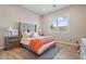 Cozy bedroom with a tufted headboard, window shutters, and cheerful decor at 30271 N 117Th Dr, Peoria, AZ 85383