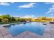 Inviting pool with a travertine surround, water features, and lush landscaping at 30271 N 117Th Dr, Peoria, AZ 85383