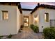 Charming home entrance with stone pathway, desert landscaping, and warm lighting for a welcoming ambiance at 3086 S First Water Ln, Gold Canyon, AZ 85118