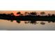 Scenic golf course view featuring a tranquil pond reflecting trees and a stunning sunset at 3086 S First Water Ln, Gold Canyon, AZ 85118