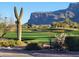 Lush green golf course with a large saguaro cactus and mountain views at 3086 S First Water Ln, Gold Canyon, AZ 85118