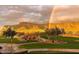 Golf course view with a rainbow over the mountains and community at 3086 S First Water Ln, Gold Canyon, AZ 85118