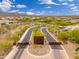 Great aerial view of gated entry to desert community with mature landscaping, mountain backdrop, blue skies and clouds at 31020 N 5Th St, Phoenix, AZ 85085