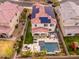 Amazing aerial view features a home with solar panels, pool, outdoor seating, and play area in a desert community at 31020 N 5Th St, Phoenix, AZ 85085