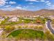 Aerial view of suburban community featuring green space, lush mature trees, mountain views, and desert landscaping at 31020 N 5Th St, Phoenix, AZ 85085