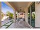 Covered patio with outdoor seating, elegant travertine pavers, and a view of the lush backyard and pool at 31020 N 5Th St, Phoenix, AZ 85085