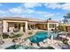 Backyard oasis showcasing a pool with rock waterfall feature, covered patio and lush landscaping at 32020 N 20Th Dr, Phoenix, AZ 85085
