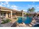 Stunning backyard featuring a sparkling pool with rock waterfall, an outdoor kitchen, and a covered patio at 32020 N 20Th Dr, Phoenix, AZ 85085
