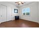 Inviting bedroom with wood floors, a ceiling fan, a small writing desk, and sliding closet doors at 32020 N 20Th Dr, Phoenix, AZ 85085