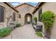 Charming home entrance with stone accents, water fountain, desert landscaping, and a decorative black iron entry door at 32020 N 20Th Dr, Phoenix, AZ 85085