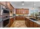 Gourmet kitchen featuring stainless steel appliances, granite countertops, gas cooktop and rich dark wood cabinets at 32020 N 20Th Dr, Phoenix, AZ 85085