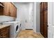 Laundry room equipped with a washer, dryer, and custom wood cabinets at 32020 N 20Th Dr, Phoenix, AZ 85085