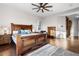 Spacious main bedroom featuring hardwood floors, ceiling fan, and a beautifully crafted wood bed frame at 32020 N 20Th Dr, Phoenix, AZ 85085