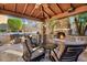 Outdoor kitchen with stone fireplace, built-in grill, bar, and ample seating for entertaining by the pool at 32020 N 20Th Dr, Phoenix, AZ 85085