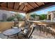 Beautiful covered outdoor living area featuring seating, a bar, and a waterfall pool feature at 32020 N 20Th Dr, Phoenix, AZ 85085