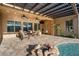 Covered patio featuring stone pavers, ceiling fans, outdoor furniture and nearby pool with a rock fire pit at 32020 N 20Th Dr, Phoenix, AZ 85085