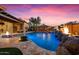 Stunning backyard pool with rock features, outdoor kitchen, and beautifully designed landscaping at 32020 N 20Th Dr, Phoenix, AZ 85085