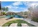 Inviting outdoor space with a pool, rock waterfall, spa, outdoor kitchen and lounge chairs on a manicured lawn at 32020 N 20Th Dr, Phoenix, AZ 85085