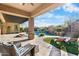 Covered outdoor living space with lounge seating overlooking a pool with waterfall feature and mature landscaping at 32020 N 20Th Dr, Phoenix, AZ 85085