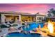 Inviting backyard pool with baja shelf, rock features, and outdoor lounge area at twilight at 32020 N 20Th Dr, Phoenix, AZ 85085