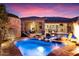 Beautiful backyard pool with rock waterfall and luxurious lounge seating at twilight at 32020 N 20Th Dr, Phoenix, AZ 85085