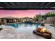 Backyard pool with covered outdoor kitchen, fire features, and beautiful landscaping at 32020 N 20Th Dr, Phoenix, AZ 85085