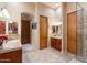 Neutral toned bathroom featuring tile flooring, wood doors, dual sinks, and walk in shower at 33269 N 73Rd Pl, Scottsdale, AZ 85266