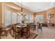 Open-concept dining room with a chandelier, multiple windows, tile floors, and comfortable wooden furniture at 33269 N 73Rd Pl, Scottsdale, AZ 85266