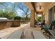 Outdoor patio with built-in BBQ, stone flooring, lounge chairs, and a ceiling fan at 33269 N 73Rd Pl, Scottsdale, AZ 85266