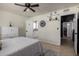 Bright bedroom featuring tile floors, white bedding, ceiling fan and ensuite bathroom at 3516 W Brown St, Phoenix, AZ 85051