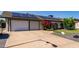 Inviting home with a spacious driveway, blooming flowers, and solar panels enhancing energy efficiency at 3516 W Brown St, Phoenix, AZ 85051