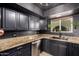 Modern kitchen featuring granite countertops, stainless steel appliances and black cabinets at 3516 W Brown St, Phoenix, AZ 85051
