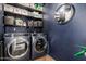 Well-organized laundry room with modern washer and dryer, shelving, and a decorative mirror at 3516 W Brown St, Phoenix, AZ 85051