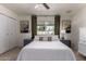 Cozy bedroom with a large window, neutral tones, and a ceiling fan for a relaxing retreat at 3516 W Brown St, Phoenix, AZ 85051