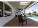Spacious covered patio featuring ample seating and view to the pool and manicured backyard at 3516 W Brown St, Phoenix, AZ 85051