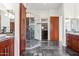 Spacious primary bathroom featuring dark stone flooring, a glass-enclosed shower, and wooden cabinets at 38199 N Tranquil Way, Carefree, AZ 85377