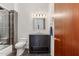 Stylish bathroom with a granite vanity, updated tile in shower, toilet, and wood door at 38199 N Tranquil Way, Carefree, AZ 85377
