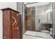 Updated bathroom with decorative wood cabinet with view of a tiled shower and glass door at 38199 N Tranquil Way, Carefree, AZ 85377