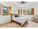 Light bedroom with hardwood floors, ceiling fan, and large windows featuring rustic shutters at 38199 N Tranquil Way, Carefree, AZ 85377